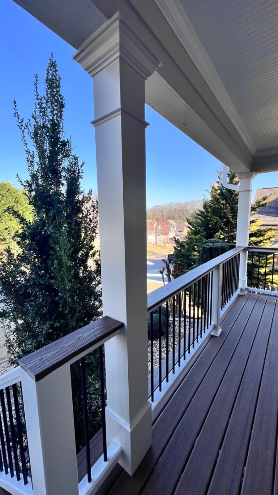 Clean sightlines down the rebuilt porch with black aluminum balusters