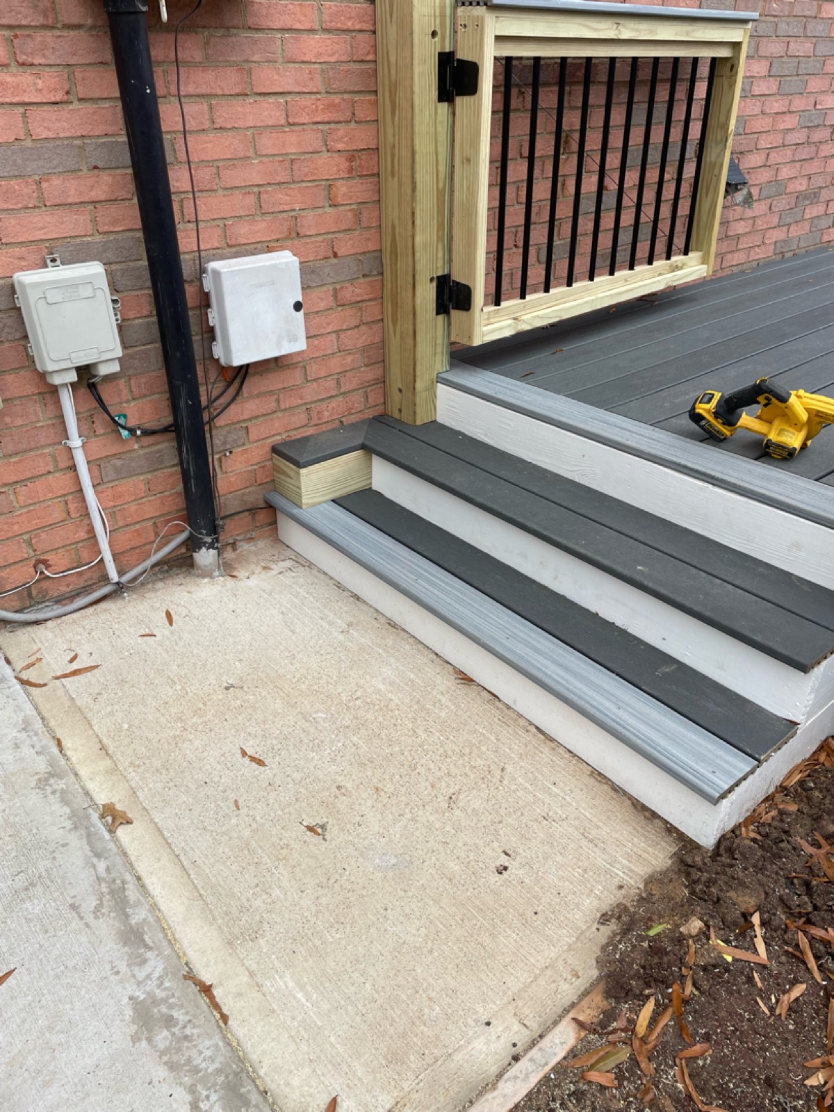 Finished Trex stairs with a divider panel to screen the relocated AC units